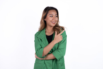 Smiling beautiful Asian woman pointing finger upward to empty space in studio white isolated background.