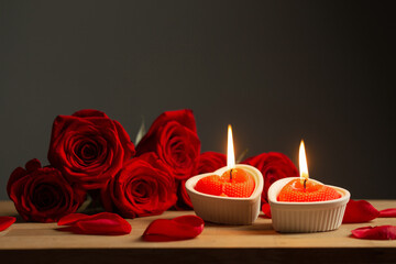 red roses with burning candles on dark background