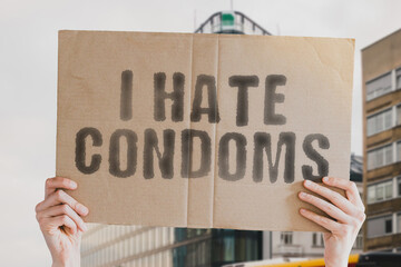 The phrase " I Hate Condoms " is on a banner in men's hands with blurred background. Contraceptive. Control. Education. Health Care. Medical. Medicine. Pregnancy. Prevention. Aids. Health. Care