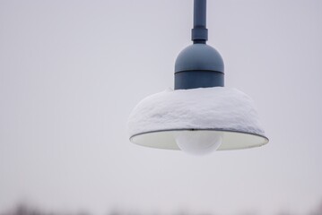 Snow-covered lamp of a public streetlight.