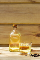 Sunflower oil in a bottle glass with seeds on the wooden background