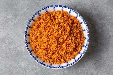 Traditional turkish bulgur pilaf with tomato sause in plate (Turkish name; meyhane pilavi)