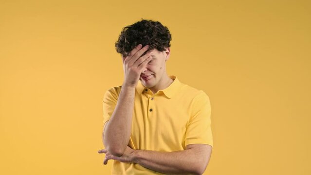 Worried man doing face-palm gesture, like no, I forgot. Disappointed guy feeling sorrow, regret, drama, failure, problems on yellow background.