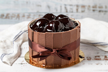 Profiterole and chocolate cake. Celebration or birthday cake on a white wood background. close up