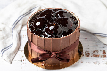 Profiterole and chocolate cake. Celebration or birthday cake on a white wood background. close up