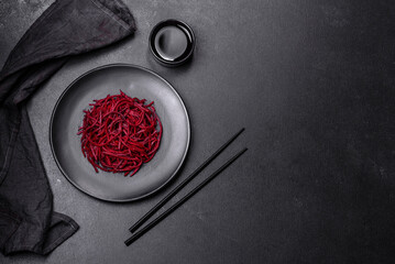 Tasty spicy Korean beet with spices and herbs on a dark concrete background