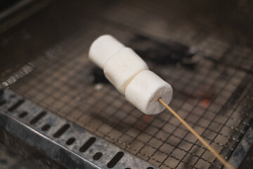 A white fluffy Marshmallow grilled. Concept of camping, party family time, campfire evening and activitiy.