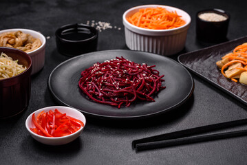 Tasty spicy Korean beet with spices and herbs on a dark concrete background