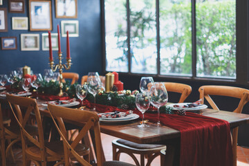 Christmas table setting and set up for traditional lunch or dinner on a wooden table with, tableware and festive decorations. Concept of family traditions and celebrations. or reserved restaurant.