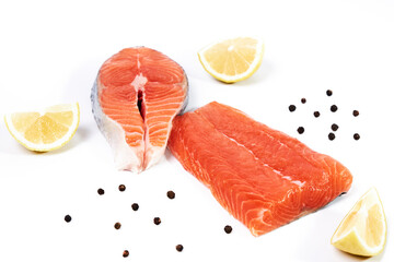 Salmon, fillet and slice of fresh raw fish with lemon slices and black pepper, isolated on white background