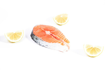 Salmon, slice of fresh raw fish together with lemon slices, isolated on white background