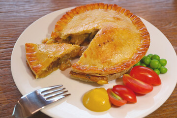 A Plate of Delectable Golden Brown Beef Pie Served on Wooden Table