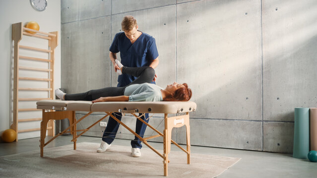 Advanced Sport Physiotherapy Specialist Stretching and Working with Specific Muscles Groups or Joints with Elderly Woman. MIddle Aged Female Recovering from Mild Injury, Rehabilitation in Clinic. - Powered by Adobe