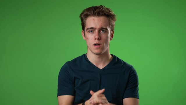 Young worried pleading man 20s hold hands folded in prayer begging about something making wish keep fingers crossed isolated on green screen background studio. Slow motion