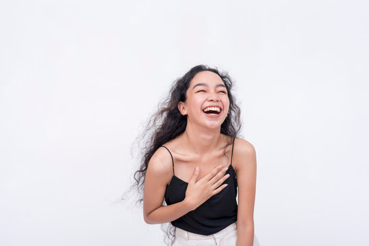 An exuberant and lively young woman laughing. A happy and lighthearted scene. Isolated on a white backdrop.