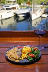 beef chop steak with salad , fried potatoes and mustard sauce in dish. Food and Vegetable concept. Restaurant and menu theme. With Red Wine.