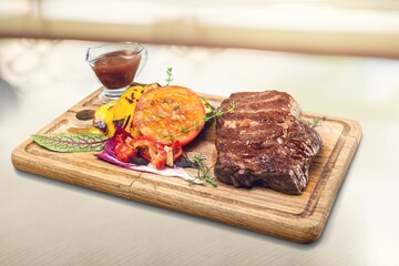 Grilled tasty meat dish on wooden board