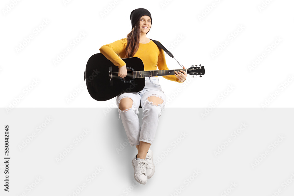 Sticker Young female musician playing an acoustic guitar and sitting on a blank panel