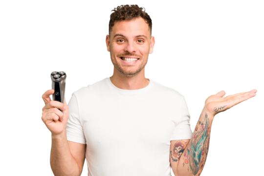 Young caucasian man holding a razor isolated showing a copy space on a palm and holding another hand on waist.
