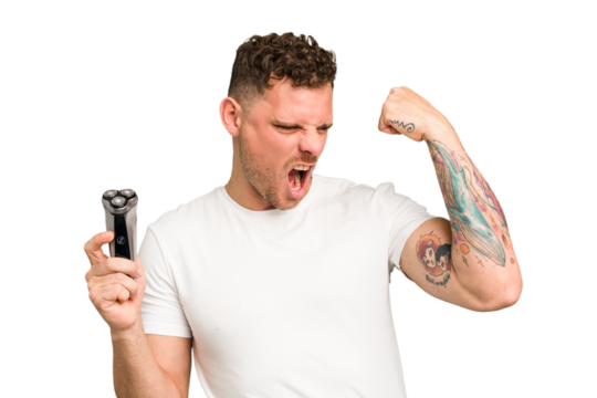 Young caucasian man holding a razor isolated raising fist after a victory, winner concept.