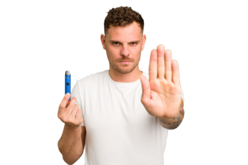 Young caucasian man holding a electronic cigarette isolated standing with outstretched hand showing stop sign, preventing you.