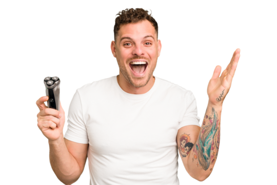 Young caucasian man holding a razor isolated receiving a pleasant surprise, excited and raising hands.
