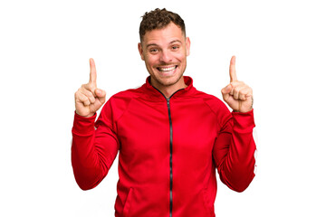 Young caucasian handsome man isolated indicates with both fore fingers up showing a blank space.