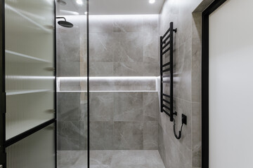 bathroom interior design with gray tiles and glass shower wall