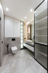 bathroom interior with gray tiles, mirror and lighting. vertical photo