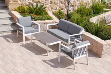 3 white and gray sofa and a table made of metal in courtyard and garden on the garden floor,...