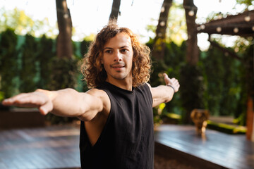 Young ginger curly man doing exercise during yoga practice