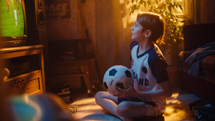 Young Excited Sports Fan Watches a Soccer Match on TV at Home. Boy Supporting His Favorite Football...