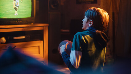 Young Sports Fan Watches American Football Match on TV at Home. Handsome Boy Supporting His...