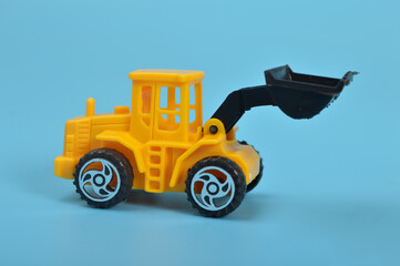 Yellow backhoe loader isolated on a blue background.