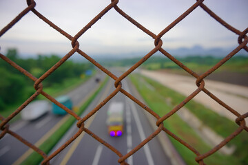 the bridge wire fence with blurred background over the toll road used to protect road users from falling when crossing the road during the day or at night