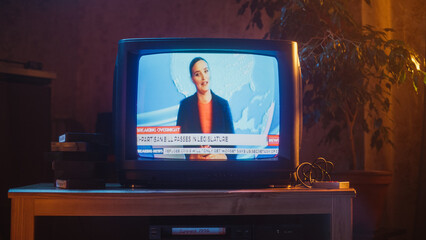 Close Up Footage of a Dated TV Set Screen with Breaking News Report. Beautiful Female Host Reads Important News on Live Television Broadcast. Nostalgic and Retro Nineties Technology Concept.