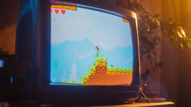 Close Up Footage of a Retro TV Set Screen with an Eight Bit Eighties Inspired Console Arcade Video Game. Quest Loading, Player Kills a Monster, Collects Hearts and a Treasure Chest, and Wins.