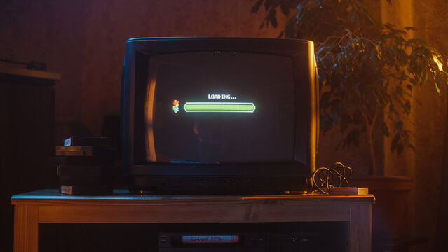Close Up Footage of a Retro TV Set Screen with an Eight Bit Eighties Inspired Console Arcade Video Game. Quest Loading, Player Waiting to Start New Harder Level. Green Progress Bar Moving.