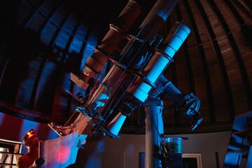 Astronomer with a big astronomical telescope in observatory doing science research of space and...