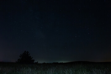 Milky Way stars with countryside landscape.