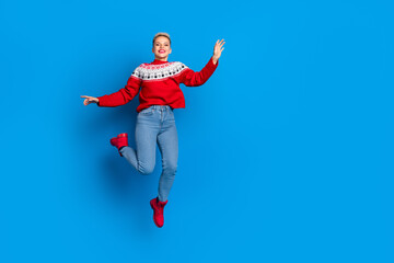 Naklejka na ściany i meble Full body photo of nice jumping air active woman wear red ornament sweatet celebrate winter season sale collection isoalated on blue color background