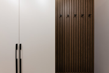 interior design of a hallway with a white cabinet and a hanger made of wood