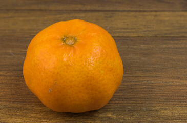 Close up view of mandarin isolated on wooden background.