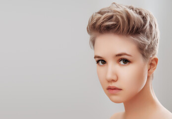 Naklejka premium Beautiful Young Woman with Clean Fresh Skin. Face care . Facial treatment . Cosmetology , beauty and spa . Girl with short hair. 