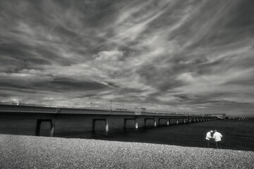 Greyscale shot of a the deal seafront and pier