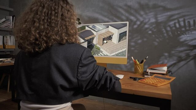 Web designer sits and works at his computer creating a layout in a beautiful office 