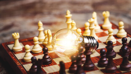 A glowing lamp in the center of the chess symbolizes the solution to a problem. Thinking and having good ideas.