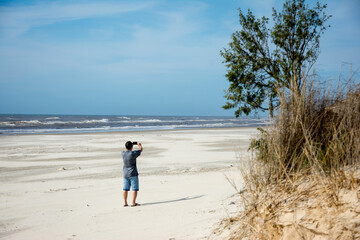 Lone man strolling on the beach