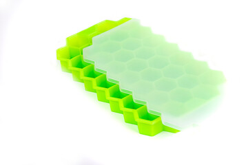 green silicone mold on a white background. the mold is designed for freezing ice. a small shadow...