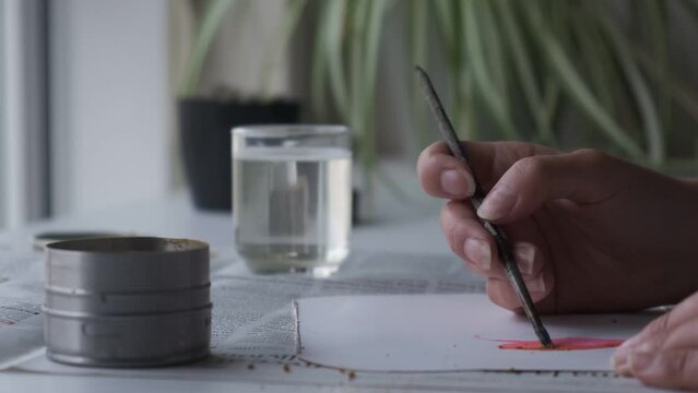 Chica pintando con pincel. Vista de las manos
